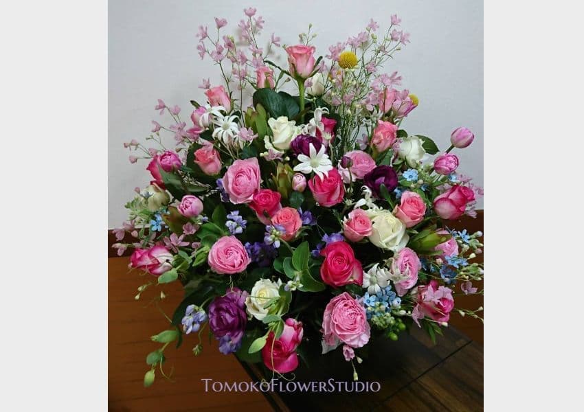 ピンクの小バラの濃淡、赤い小バラ、薄いブルーと薄いピンクの小花のアレンジ　　会社受付用のお届のアレンジ